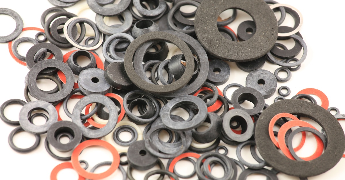 Closeup of a large pile of several different types of seals and gaskets in various sizes and colors like red and black.
