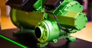 A close-up of a black and bright green hydraulic pump used in industrial applications sitting on a table.